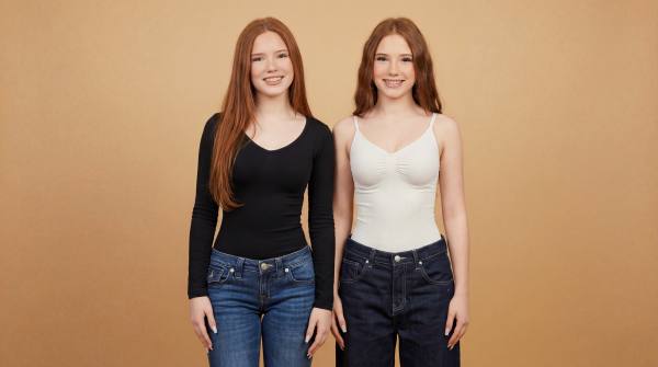 Emilia and Letizia standing in front of a beige-oragne background